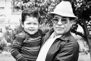 Image of a latino Mozilla employee as a child in the arms of his grandfather
