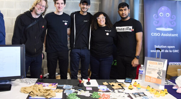 A group of Mozillians taking picture in front of the Mozilla booth at FOSDEM 2025