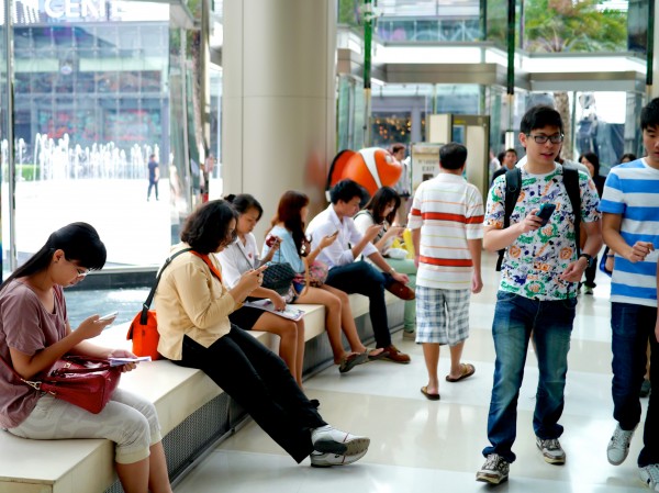 People using their mobile devices in a popular Bangkok mall. 