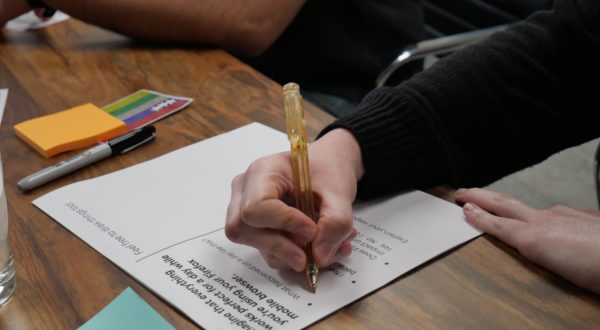 Seattle participant filling out a worksheet with an orange pen