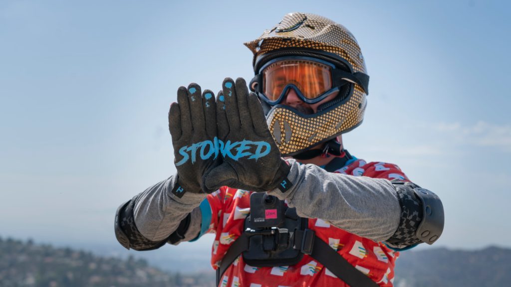Wade Holland holds up his hands, wearing gloves that read "stoked."