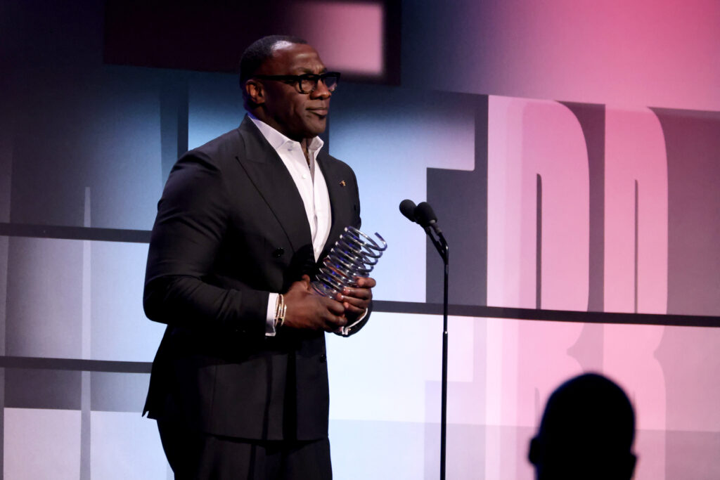 Shannon Sharpe accepts an award on stage.